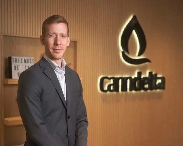Senior consultant manager, Shawn. Standing next to the company logo that reads CannDelta