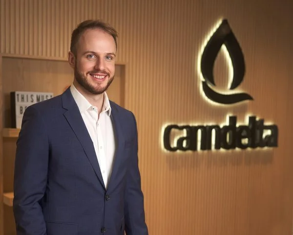 Senior consultant, Dario Jeginovic. Standing next to the company logo that reads Canndelta.