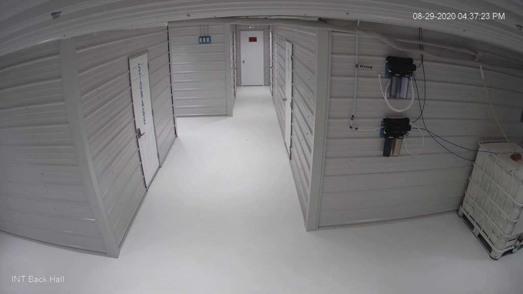 A security camera still of the corridor, note the metal clad walls, ceilings, and epoxied floors.