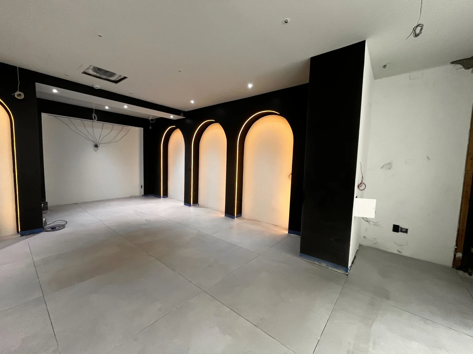 New York Dispensary in the process of being built with archways that are illuminated and painted black and white