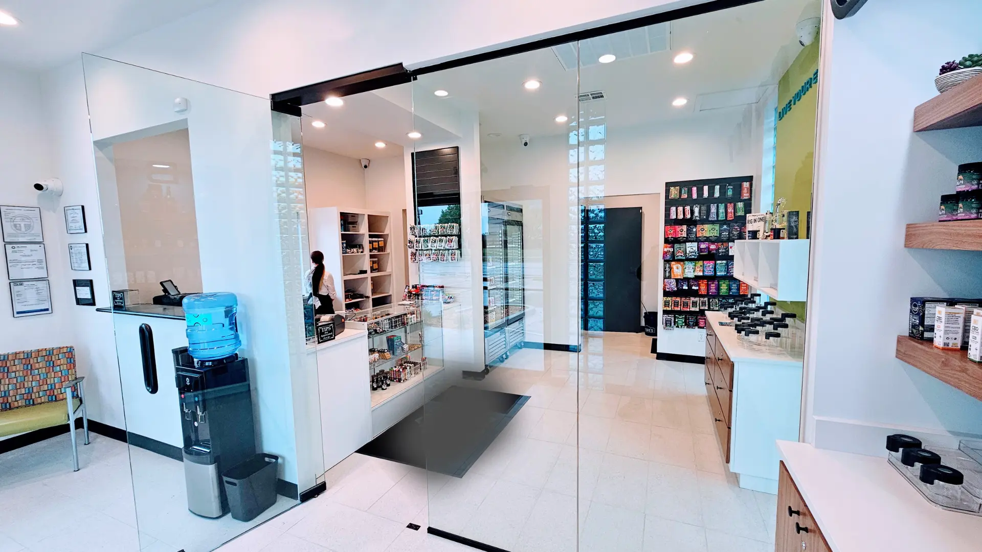 Inside of a cannabis dispensary that has white floors and ceilings.