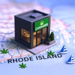 A miniature cannabis dispensary model placed on a Rhode Island map with cannabis leaf symbols and small sailboat figurines.